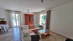 Un salón amplio con sofá, una mesa de centro de vidrio y un armario.