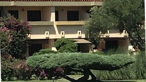 A building with a tiled roof, multiple windows, and a satellite dish.