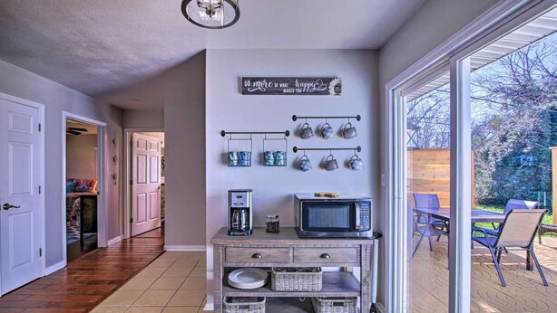 A kitchen with a coffee maker, microwave, and storage baskets on a wooden cabinet. - Cozy 4 Bedroom Home 1.1 Mile to Market Square! Late Sunday Checkouts No Problem! (Fredericksburg)