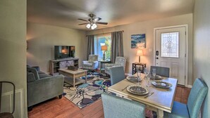 A living room with a sofa, chairs, a TV, a dining table set for four, and a ceiling fan. - Cozy 4 Bedroom Home 1.1 Mile to Market Square! Late Sunday Checkouts No Problem! (Fredericksburg)