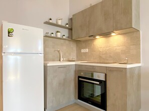 Een koelkast, een oven, een kookplaat, een koffiezetapparaat/waterkoker