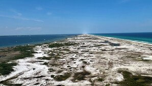 Eine Küstenlandschaft mit einem langen, schmalen Strand und freiem Blick auf den Ozean.