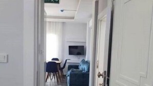 A hallway leading to a living area with a sofa and a television.