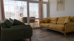 A living room with a green sofa, a yellow sofa, and a dining table with chairs.