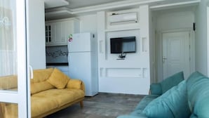 A modern living room with a sofa and a television mounted on the wall.