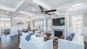 A spacious living room with white furniture, a fireplace, and a ceiling fan. - Your Luxury 30A Escape with Private Pool & Coastal Charm (Santa Rosa Beach)