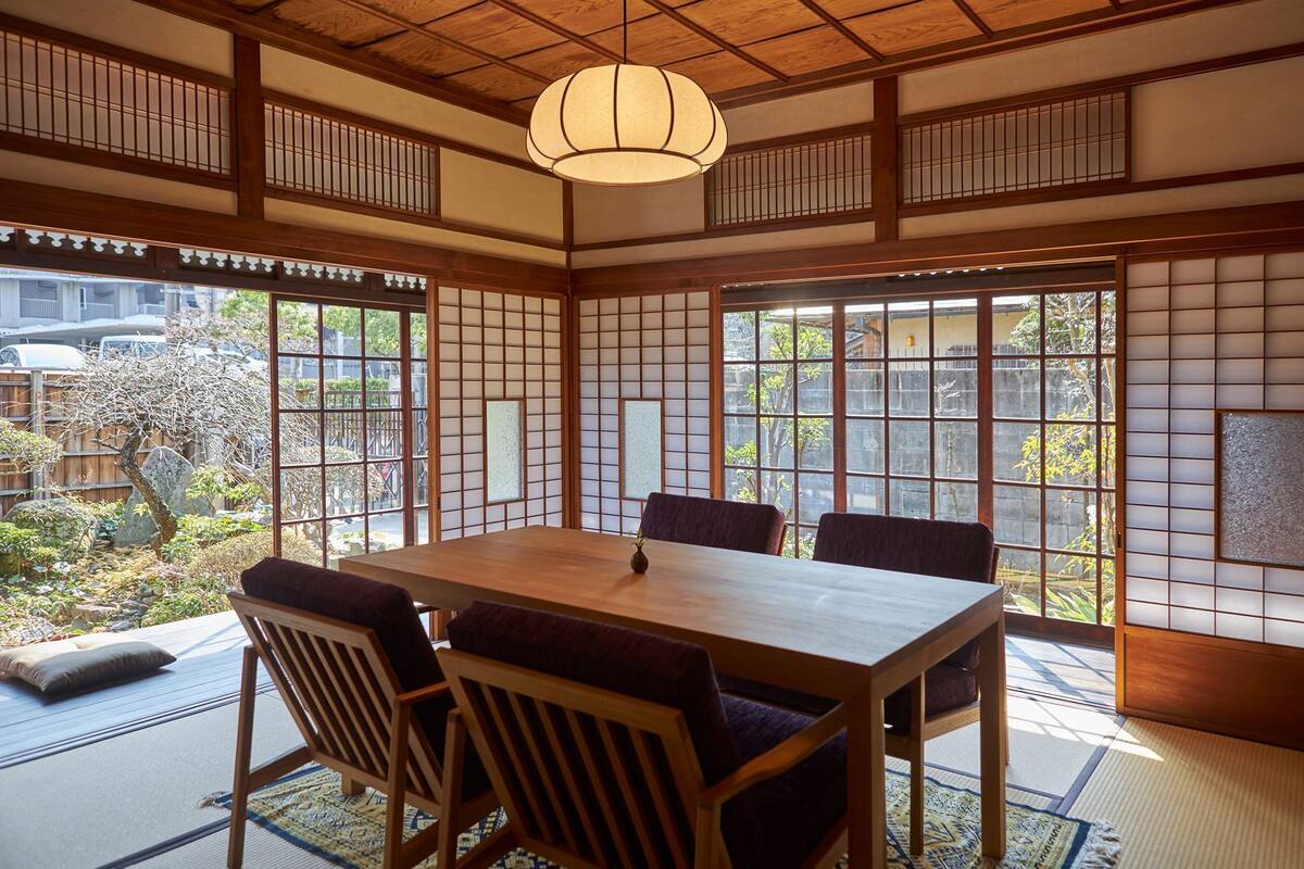 Um quarto japonês tradicional com tatames, uma mesa de madeira e painéis shoji.