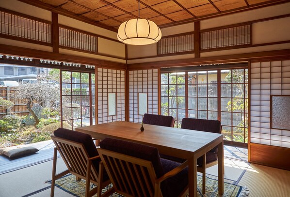 A traditional Japanese room with tatami flooring, a wooden table, and shoji screens.