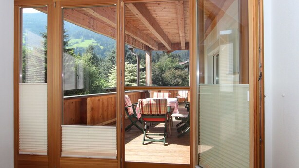 A room with a sliding glass door leading to an outdoor deck with a table and chairs. - Cosy apartment for 8 guests with WIFI, TV and patio (Taxach)