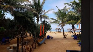 Une plage bordée de palmiers, un bateau et des chaises de plage.