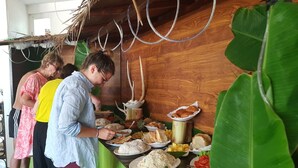 Un buffet proposant une variété de plats, dans un décor de style tropical.