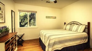 A bedroom with a bed, a window, a ceiling fan, and a wall-mounted sign. - Newly remodeled quaint Cottage (Three Rivers)