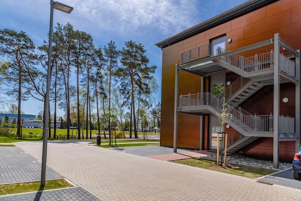 A modern building with a metal staircase and a clear sky.
