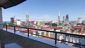 A balcony with a clear view of a cityscape, including various buildings and a distant tower. - 4 rooms apartment  (Batumi)
