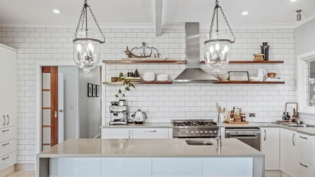 A modern kitchen with white subway tiles, a central island, hanging pendant lights, and stainless steel appliances. - Be amongst nature in the 1890s farmhouse - a time you will never forget. (Tugrabakh)