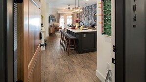 Une cuisine moderne dotée d’un îlot central, de tabourets de bar et d’un mur décoratif.