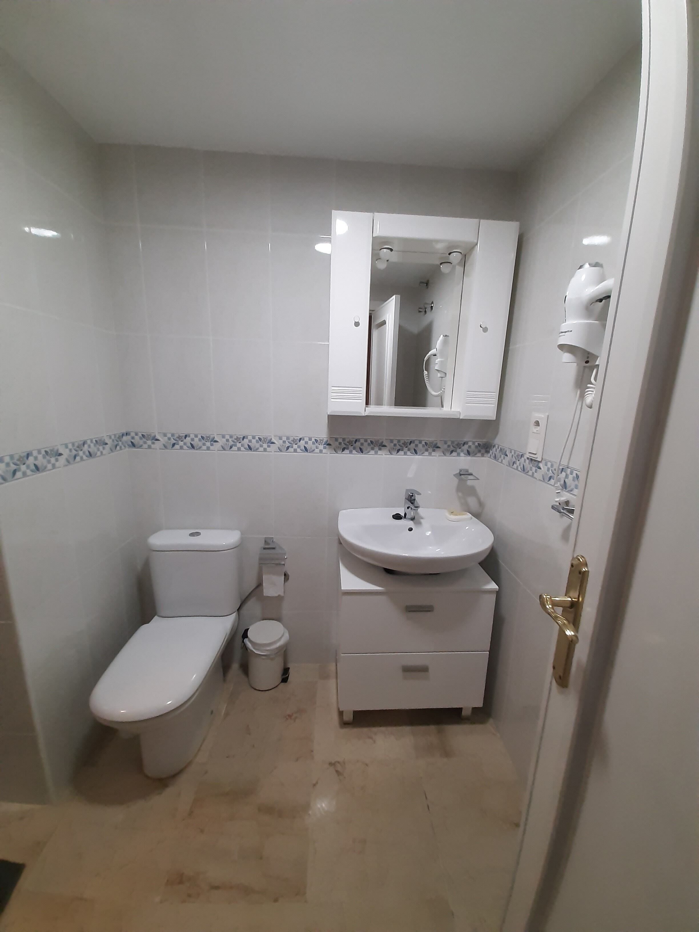 Une salle de bain avec des toilettes, un lavabo et un miroir.