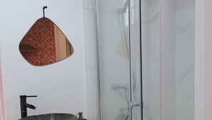 A bathroom with a glass shower enclosure, a wooden shelf with a stone basin, and a toilet. - Casa Mia Barcelona & Barça (Hospitalet de Llobregat)