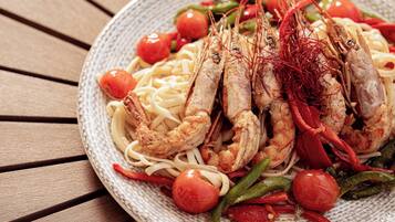 A plate of pasta with shrimp and vegetables.