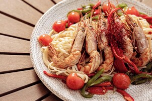 A plate of pasta with shrimp and vegetables.