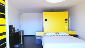 Ein Hotelzimmer mit Bett, Schreibtisch und Stuhl.