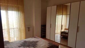 Un dormitorio con cama, armario y radiador.