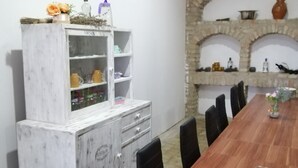 Un espace repas agrémenté d’un buffet en marbre, d’une longue table en bois et d’arcs en pierre en arrière-plan.