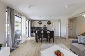 Un appartement moderne comprenant un coin repas, une cuisine et un espace de vie.