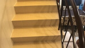 A staircase with a wooden handrail leading to a landing. - Your Home Away From Home (Talisay)