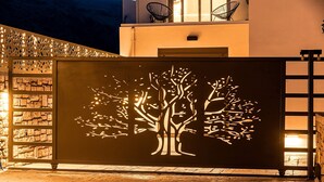 A building facade with a tree silhouette design, a stone wall, and a wooden floor.