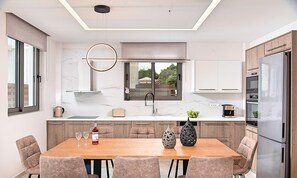 Una cucina moderna con isola centrale, forno integrato e un frigorifero capiente.