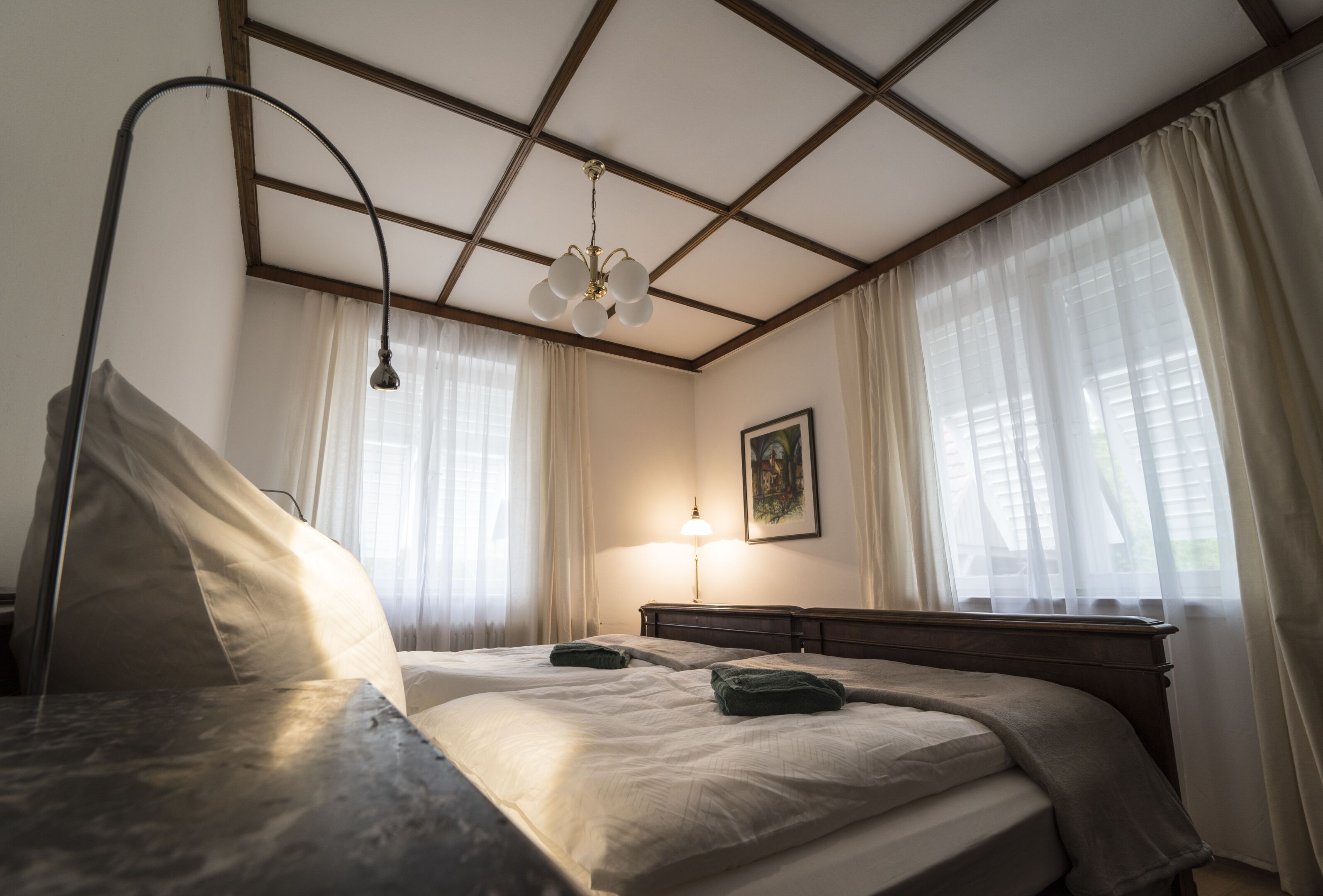 Un cuarto de hotel con una cama grande, una mesita de noche, una lámpara y un cuadro en la pared.