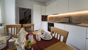 Une cuisine moderne avec des armoires blanches, un plan de travail en bois et un lave-vaisselle encastré.