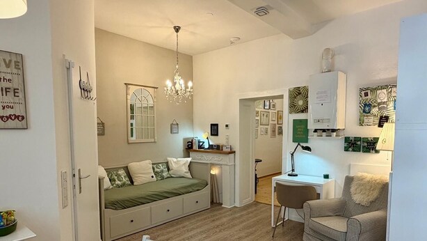 A compact living space with a bed, a dining table, a chair, a desk, and a small kitchenette. - Apartment with garden + free parking lot -T1 (Wien)