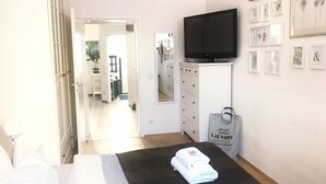 A hotel room with a bed, a TV, a dresser, and a mirror. - Apartment with garden + free parking lot -T1 (Wien)