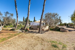 A house with a stone facade, surrounded by trees and a gravel path. - Villa Itaca Garden - Bilo by BarbarHouse (Porto Cesareo)