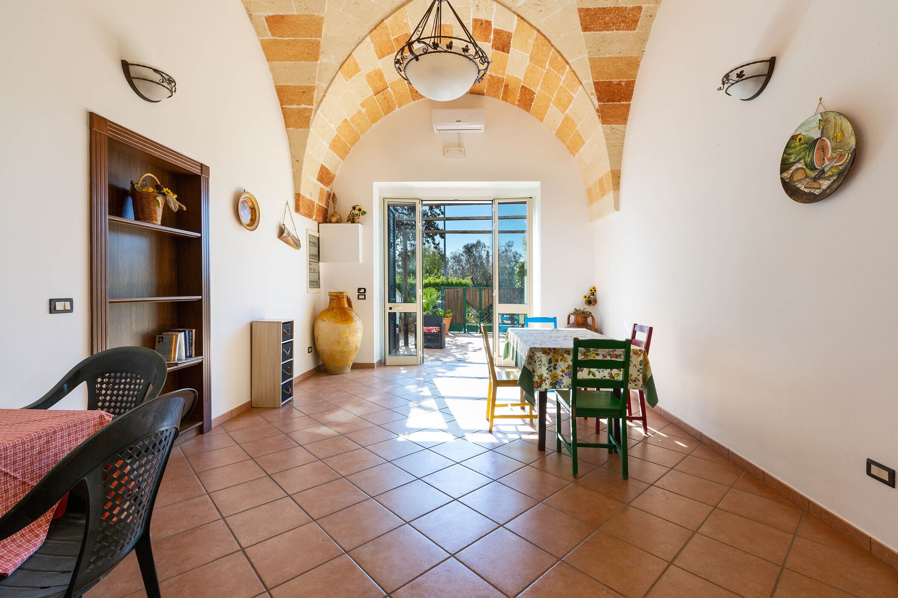 A spacious dining area with a high arched ceiling, a large window, and a view of the outdoors.