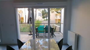 Un espace repas moderne avec une porte vitrée donnant sur un balcon extérieur.