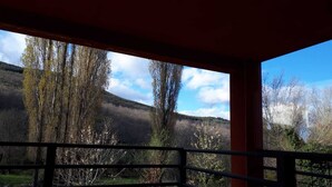 A view from a balcony with a railing, overlooking a hilly landscape with trees and a clear sky. - CASA SIERRA AVELLANEDA AVILA SPAIN (Avellaneda)