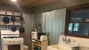 A compact kitchen with a stove, oven, microwave, and sink. - Unplug and kick back! Simple, relaxing cabin on the Clam River. (Marion)