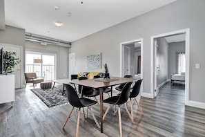 A modern dining area with a rectangular table, black chairs, and a wooden floor. - High-end condo downtown Kingston near RMC/Queens (Kingston)