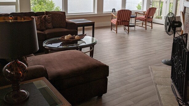 A spacious living room with a large window overlooking a lake, a ceiling fan, and a fireplace. - Stunning views of Lake Washington (Seattle)