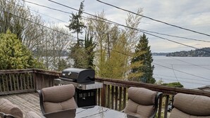 A deck with a table and chairs, overlooking a body of water. - Stunning views of Lake Washington (Seattle)