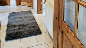 Ein Flur mit Holztüren, einem Heizkörper und einem gerahmten Bild an der Wand.