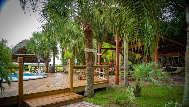 Une terrasse en bois avec une pancarte indiquant « La piscine d’Emily », qui mène à l’espace piscine.