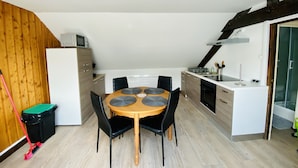Een kleine keuken met een eethoek, houten wanden en een modern design.