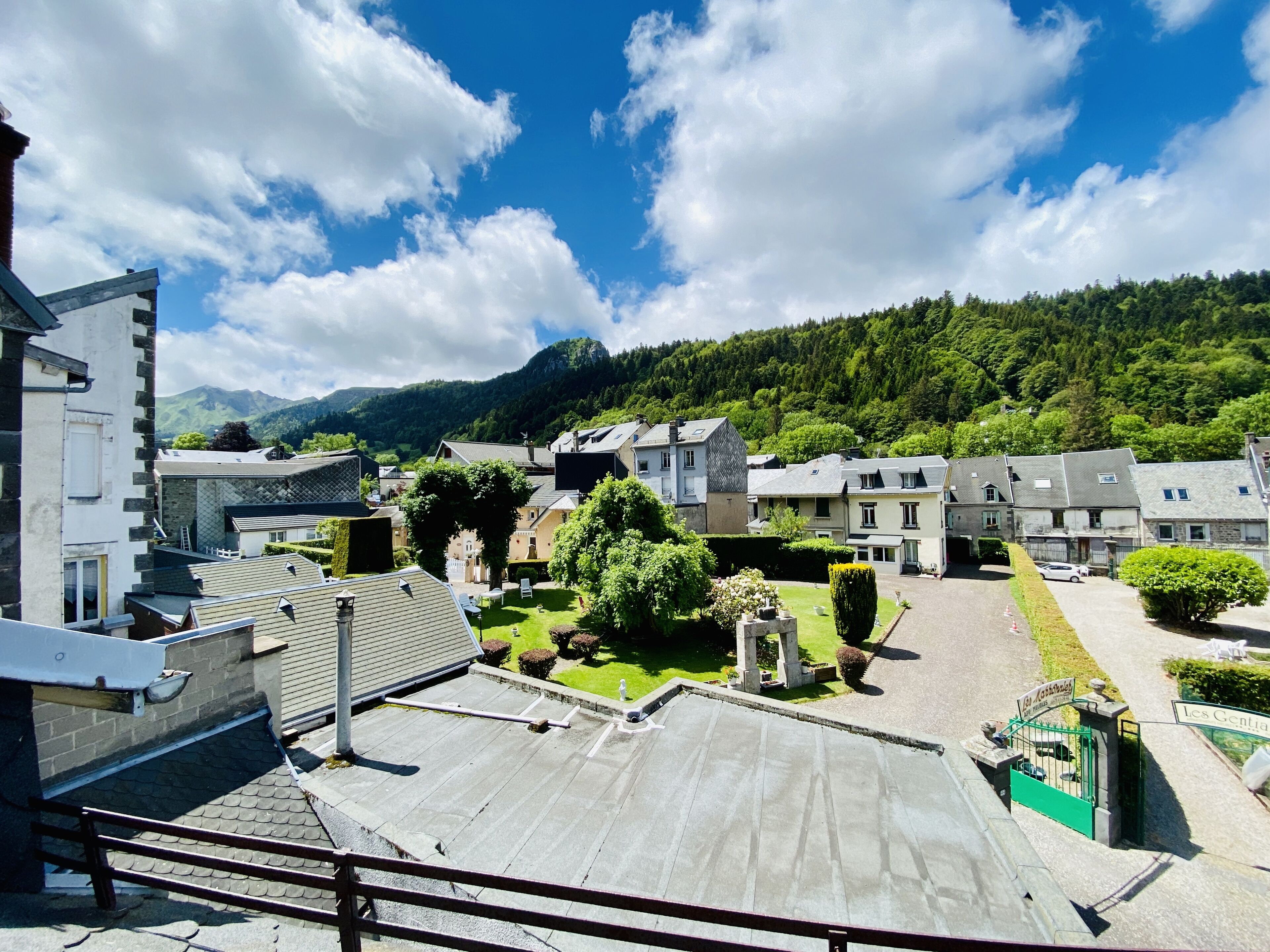 A residential area with houses, a courtyard, and a mountain backdrop.
