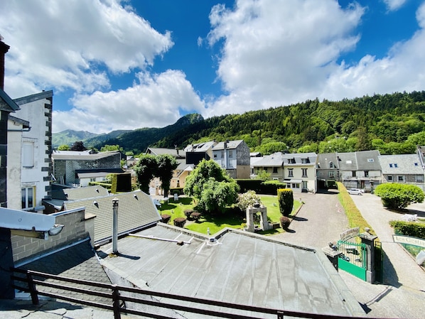 A residential area with houses, a courtyard, and a mountain backdrop. - Résidence les pâquerettes N4 (Mont-Dore)