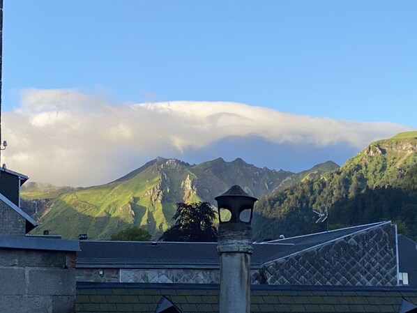 Un paisaje montañoso con un edificio en primer plano.