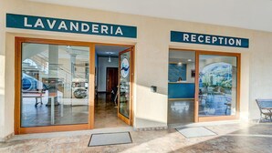 Een hotel lobby met een receptie en een bloemenwinkel met lavendel.